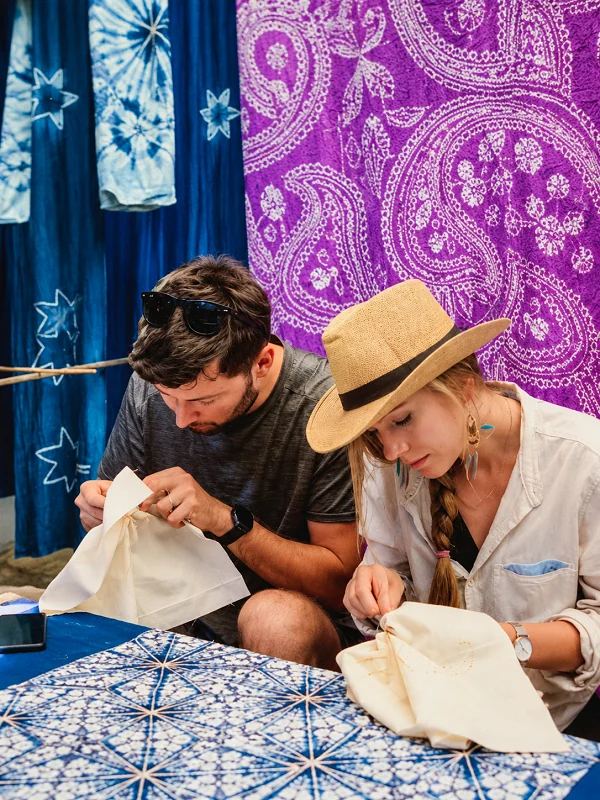 Travelers learning textile embroidery at a workshop