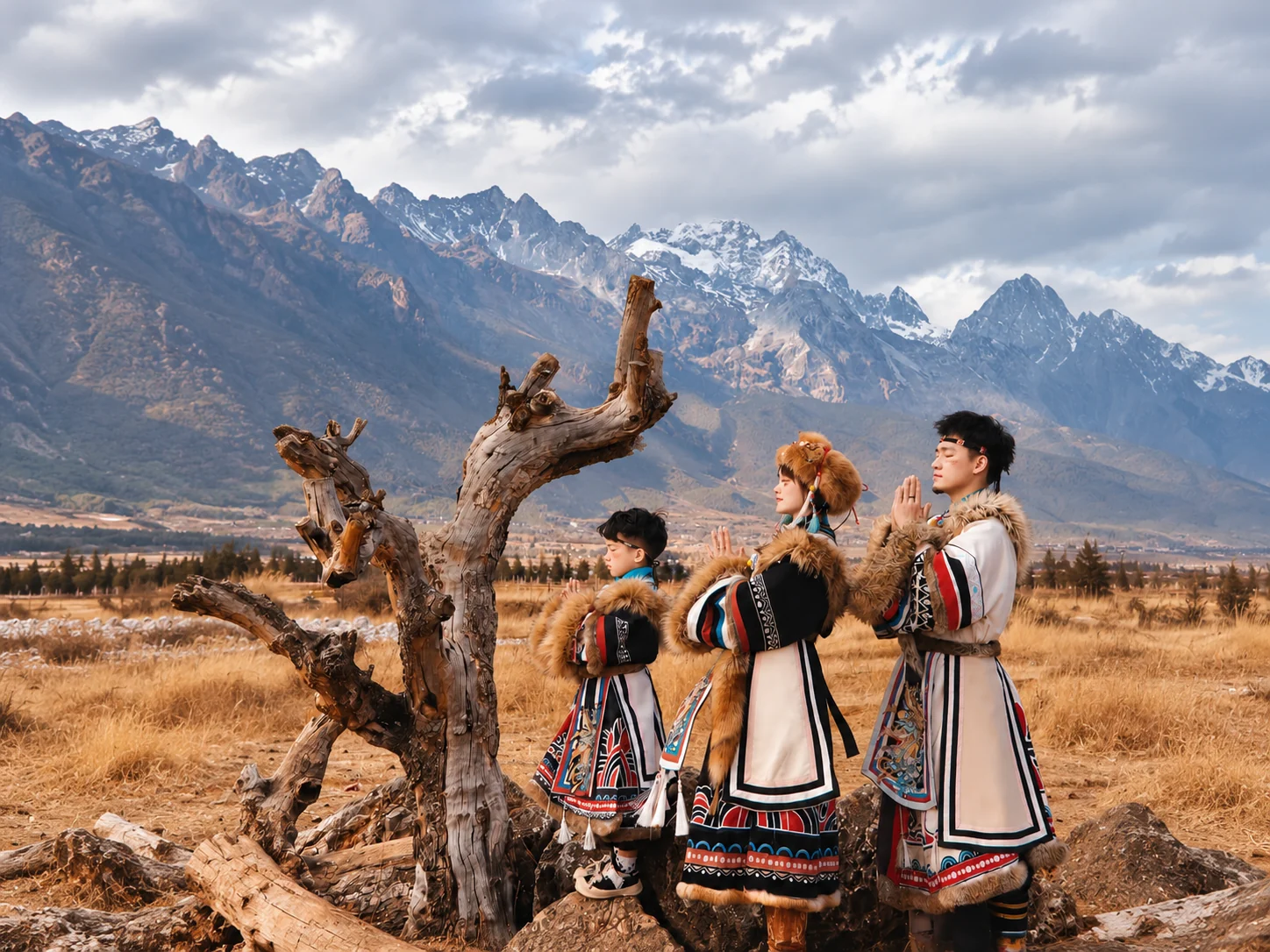Family in traditional dress before a Yunnan mountain range